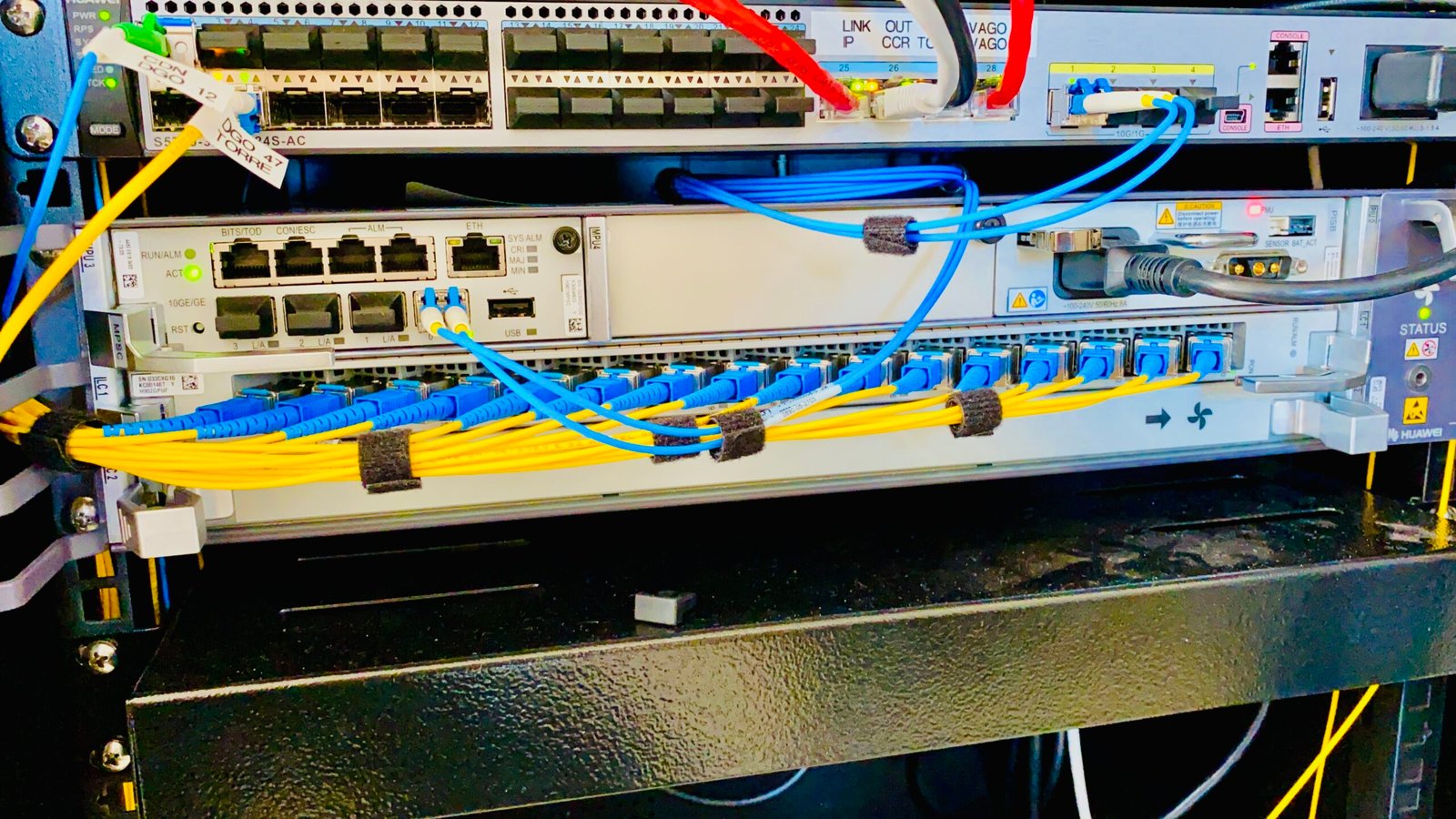 Foto mostra uma OLT x2 Huawei e um Switch Huawei